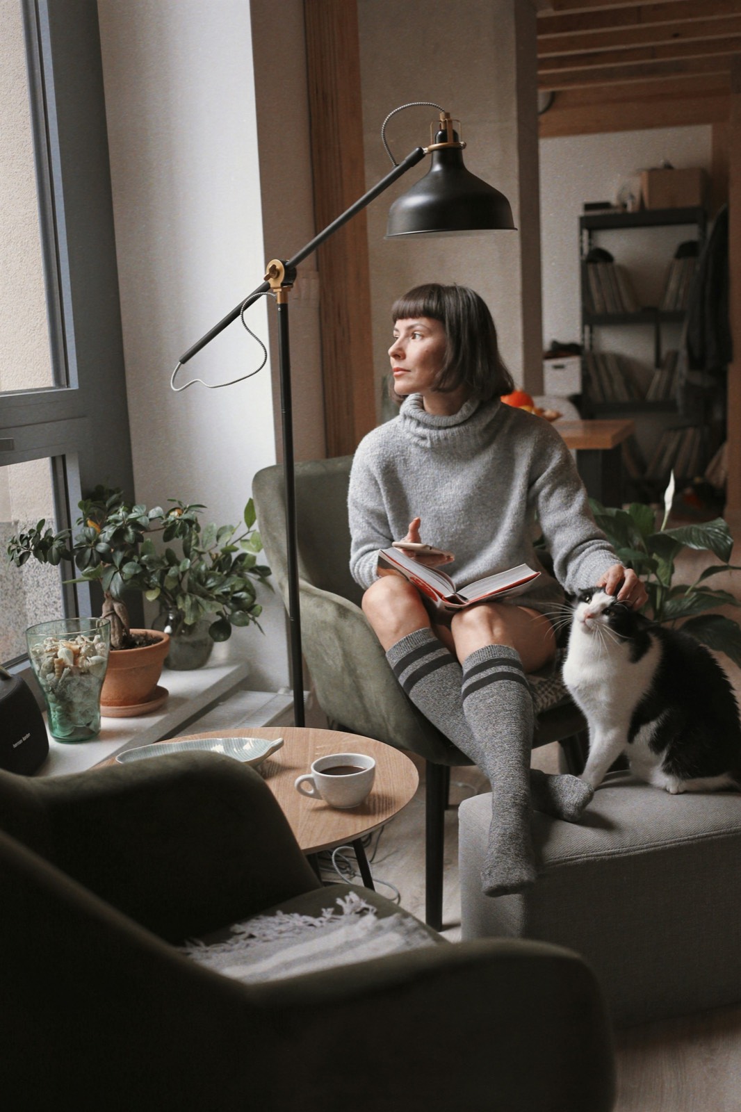 A woman sitting on a sofa at home writing in a notebook